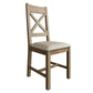 Oak cross back dining chair with beige padded seat. Product only view at an angle