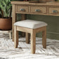 Oak dressing stool with padded seat is shown in a room setting next to a matching oak dressing table