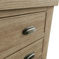 Close view on cup handles with antique effect of the drawers of the narrow oak dresser