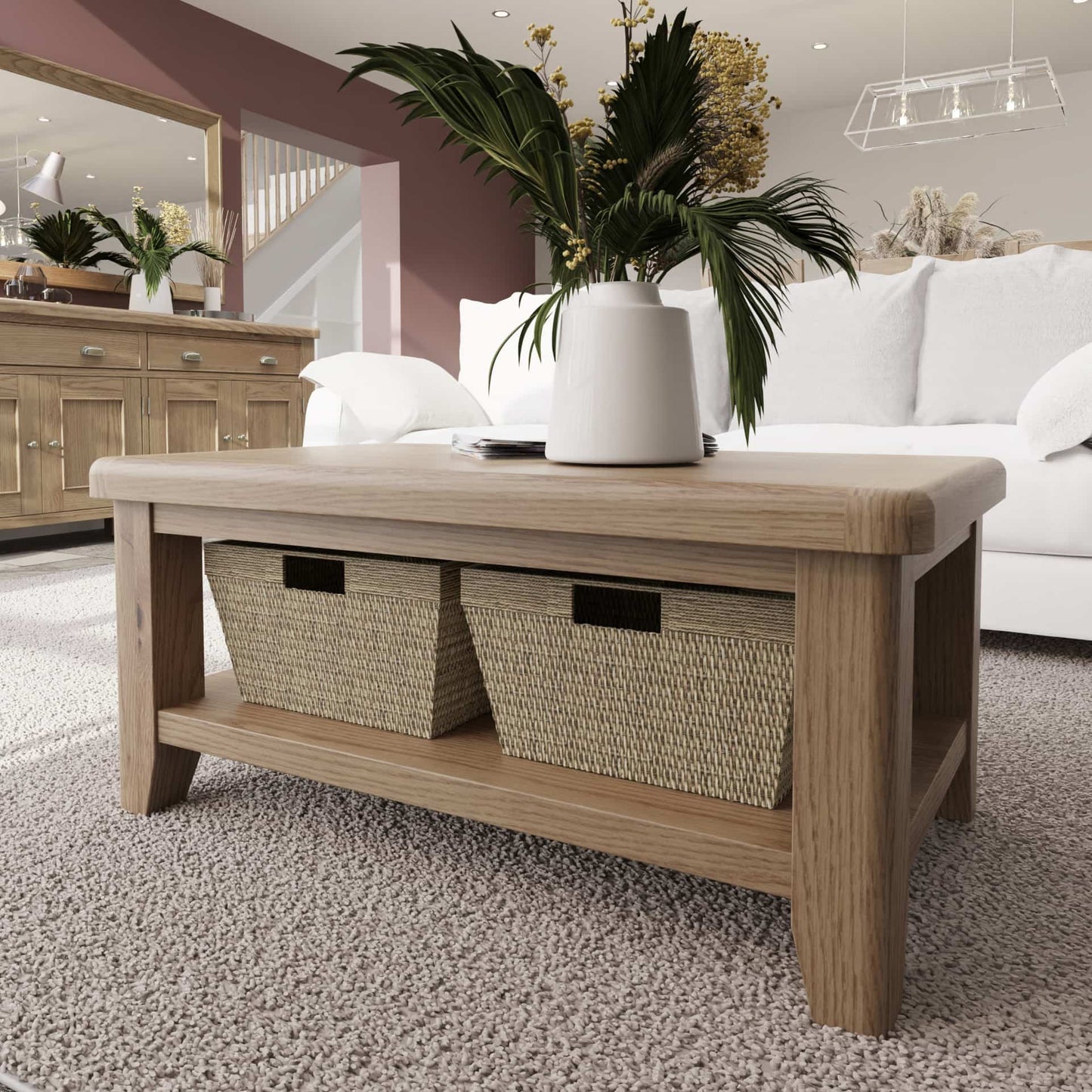 Oak Coffee Table with 4 wicker baskets is shown in a room setting standing on a  carpet with flowers and journals on top 