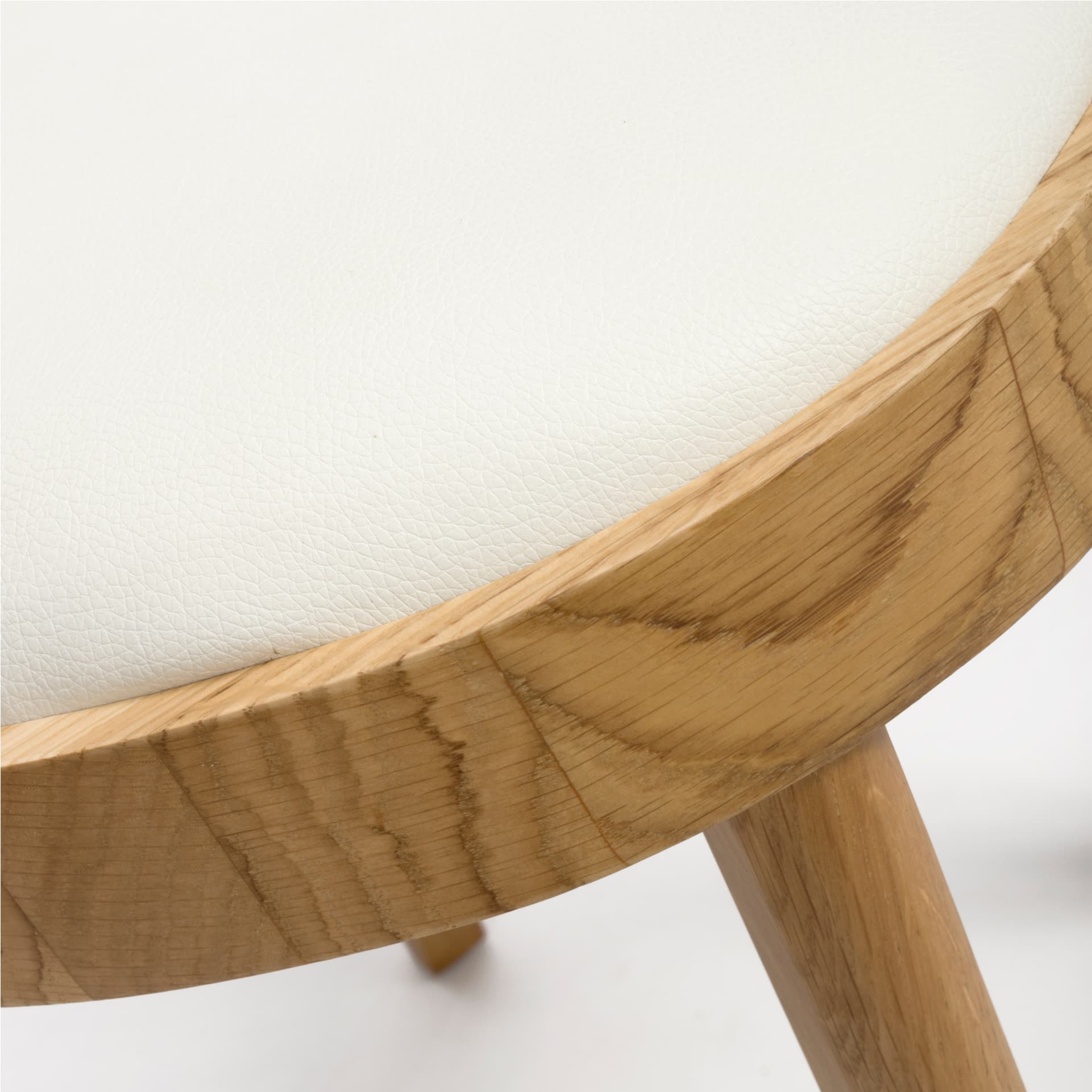 Close view on cream/ivory PU faux leather seat of a dining chair