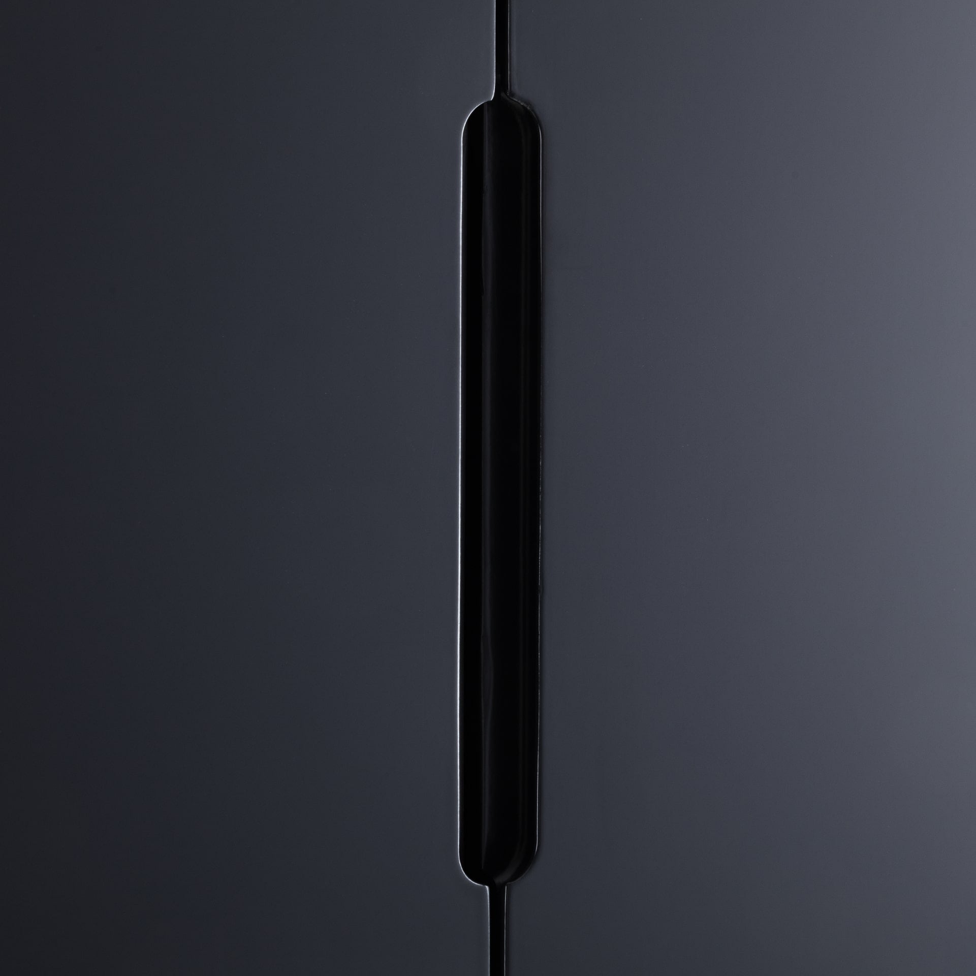 recessed handles of a charcoal black wardrobe shown close