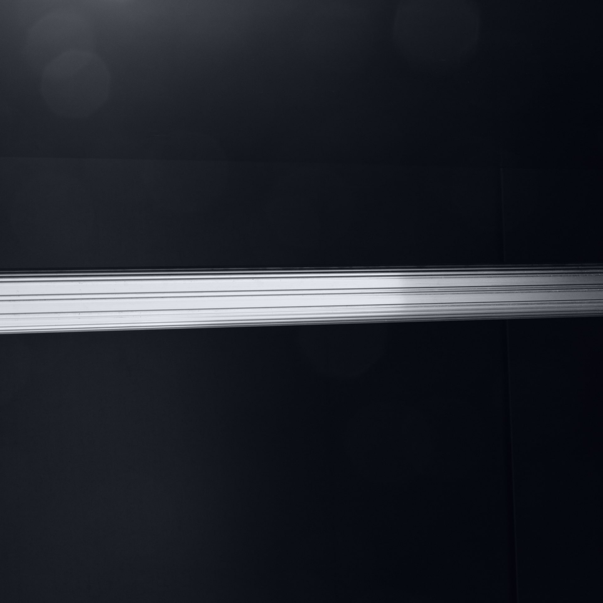 Close look on a hanging rail of the black 2 door wardrobe