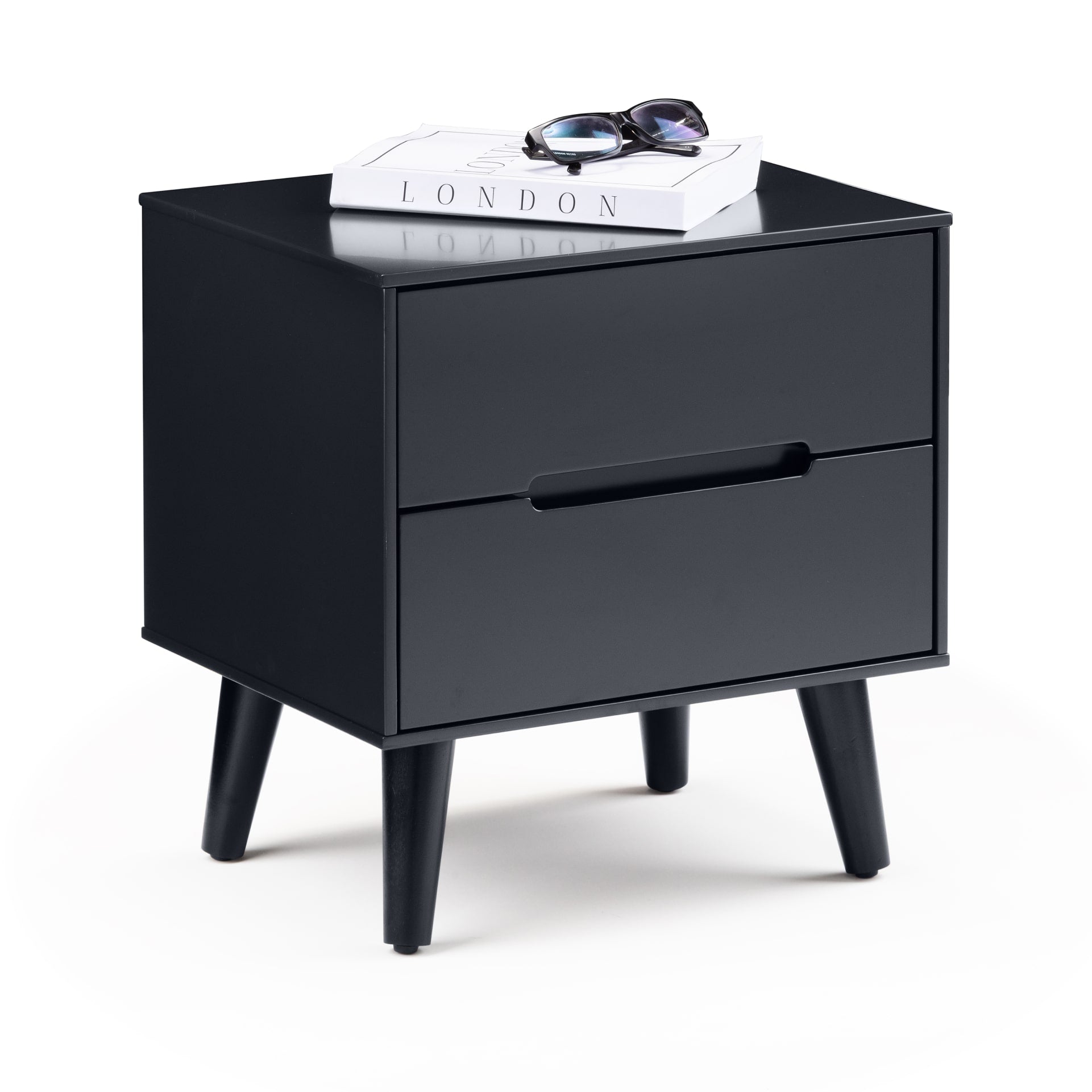 2 drawer bedside table in charcoal black colour is shown on white background without distractions. On the top of the table there is a book and sunglasses to visualise available space 