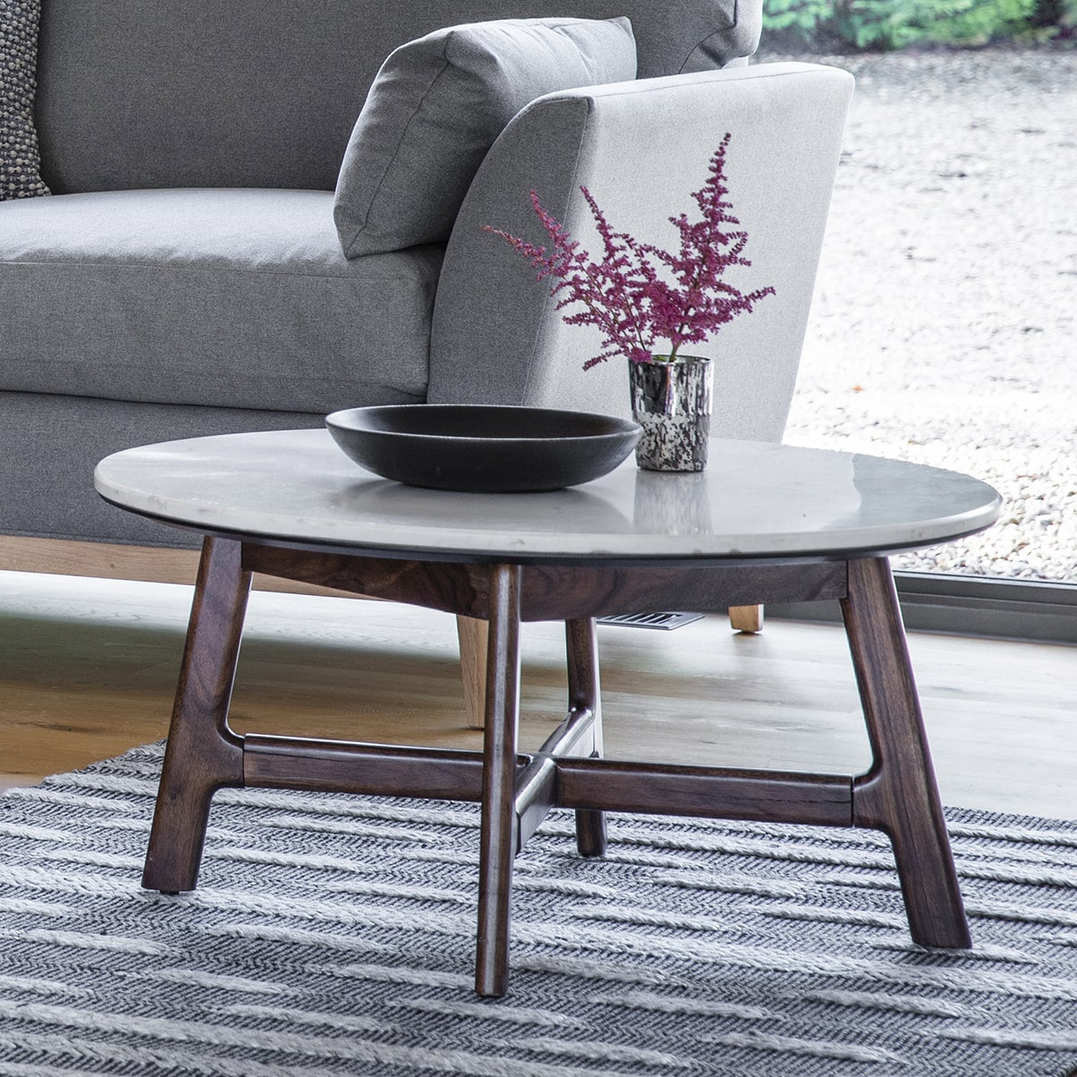 Closer look at marble top surface and wooden leg structure of round coffee table in scandinavian minimalist style