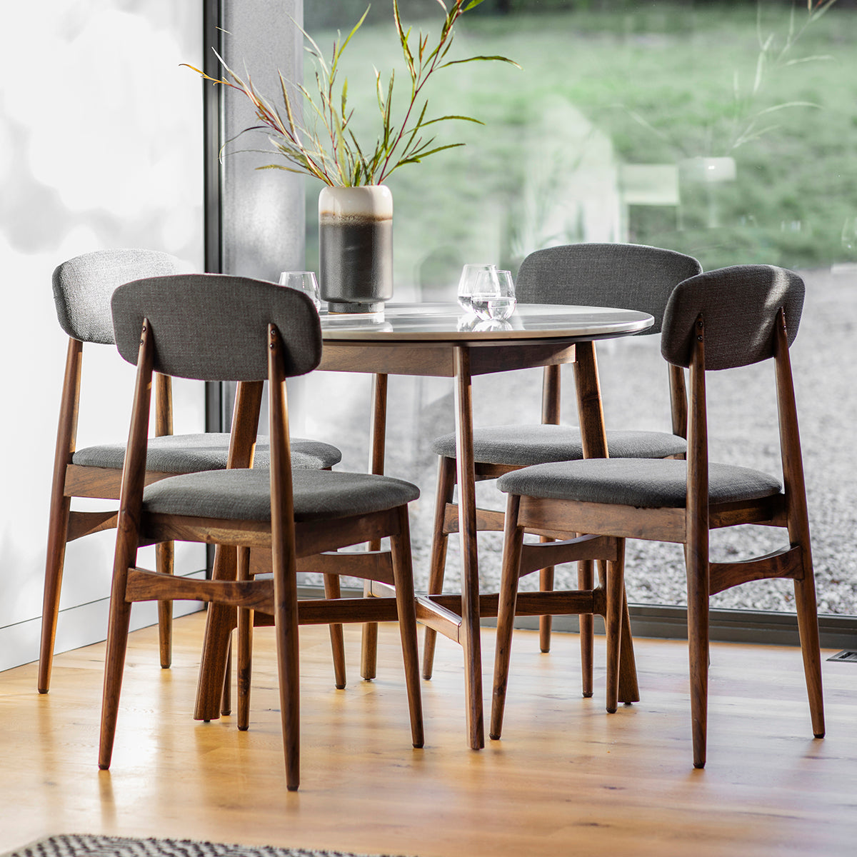 Four Andalusia Dining Chairs around round dining table in the room setting with decor