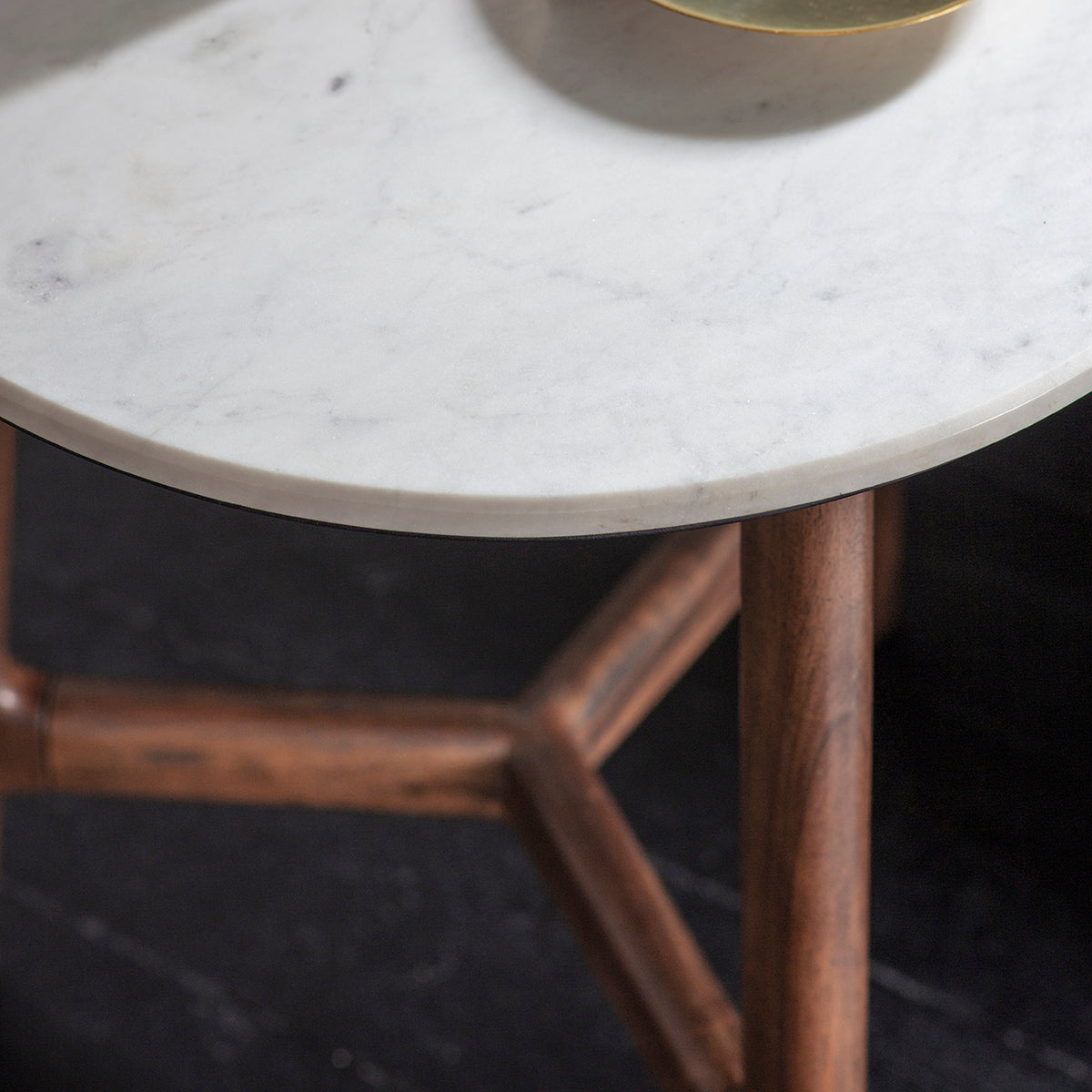 Zoom on white marble top and legs of the round side table