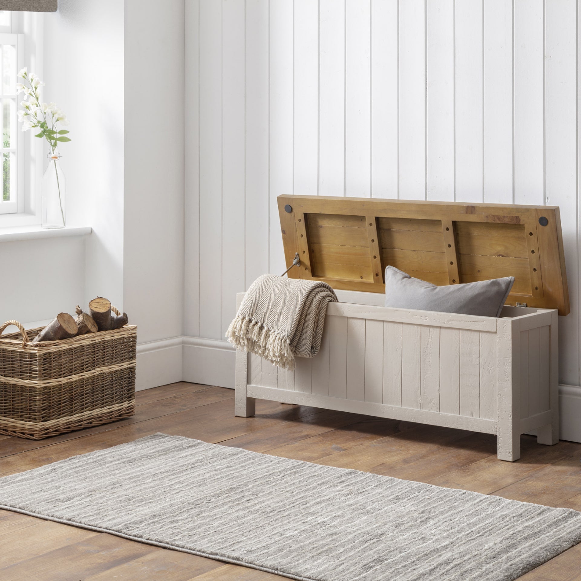 Grey and light wood storage bench from reclaimed pine is shown with open storage in a mudroom interior
