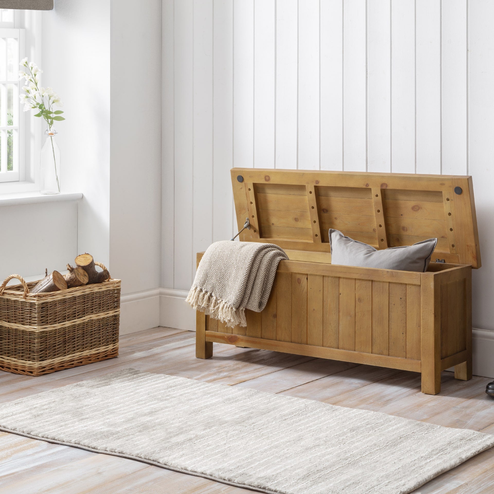 Storage bench from reclaimed pine wood is shown in a hallway / mudroom interior with storage open