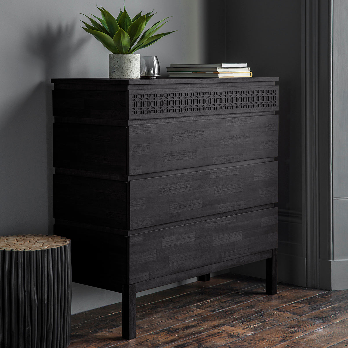 Magnificent black chest with 4 drawers of storage is shown in the room setting with decor. The front of the top drawer has a stunning frieze of the blind fretwork and the drawers are made with mixed wood veneers put together in a mosaic manner shimmering in the light.