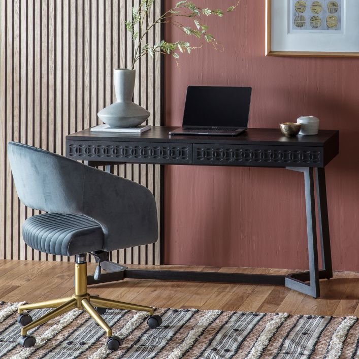 Lifestyle picture of the two drawer geometric black wooden desk in a room setting with a chair