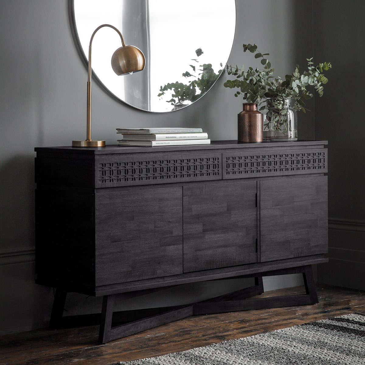 Magnificent black sideboard with 2 drawers and 3 cupboards of storage is shown in the room setting with decor. The front of the drawers has a stunning frieze of the blind fretwork and the drawers are made with mixed wood veneers put together in a mosaic manner shimmering in the light,. 