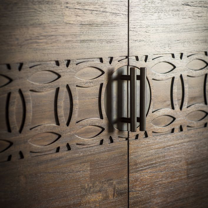 Close-up look at the door handles and carved decor of the wooden 2 door cabinet.