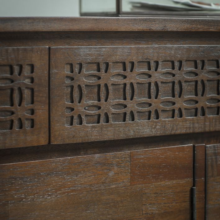 Angled view on the fretwork on drawers, veneers on cupboard doors and door attachment of the 2 drawer 3 door brown wooden sideboard